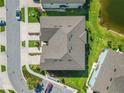 Aerial view of a well-maintained townhome with a meticulously landscaped yard and nearby pond at 2895 Deer Pine Trl, Land O Lakes, FL 34638