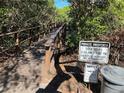 Community boardwalk surrounded by trees with signage regarding dock hours at 2910 Lichen Ln # B, Clearwater, FL 33760