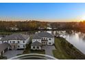 Aerial view of luxury home with tile roof, expansive lawn, and waterfront access, showcasing upscale community at 33736 Ocean Spray Ln, Wesley Chapel, FL 33543