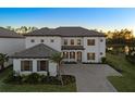 Elegant two-story home with a tile roof, a well-manicured lawn, and a paved driveway leading to a two-car garage at 33736 Ocean Spray Ln, Wesley Chapel, FL 33543