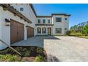 Beautiful exterior of a two-story home with paver driveway and a three-car garage at 33736 Ocean Spray Ln, Wesley Chapel, FL 33543