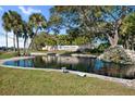 Scenic community pond showcasing a fountain and the 'Highland Lakes' active adult community sign at 3948 Tarpon Pointe Cir, Palm Harbor, FL 34684