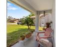 Cozy front porch with comfortable seating, potted plants, and view of the landscaped front yard at 3948 Tarpon Pointe Cir, Palm Harbor, FL 34684