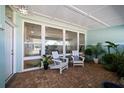 Cozy enclosed patio with brick flooring, a wall of windows, and inviting seating at 4036 Church Creek Pt, Largo, FL 33774