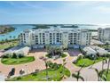 Beautiful exterior view of a condo building with manicured landscaping,circular drive and ocean view at 755 Collany Rd # 504, Tierra Verde, FL 33715