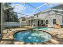 Backyard pool with a hot tub, screened-in patio, and lush green lawn at 7606 S Sparkman St, Tampa, FL 33616