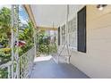 This is an inviting front porch with a swing offering a relaxing view of the surroundings at 933 E Shadowlawn Ave, Tampa, FL 33603
