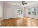 Bright living room features hardwood floors, two large windows, and white door at 933 E Shadowlawn Ave, Tampa, FL 33603
