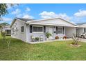 Attractive single-story home with a neatly kept lawn and a welcoming front porch seating area at 10008 Daffodil N St # 186, Pinellas Park, FL 33782
