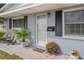 Inviting front porch with decorative plants, stylish chairs, and a charming 'HOME' welcome mat at 10008 Daffodil N St # 186, Pinellas Park, FL 33782