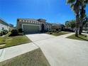 A one-story home with a wide driveway and lush green landscaping at 11193 Spring Point Cir, Riverview, FL 33579