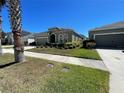 A one-story home with an attached garage and lush green landscaping at 11193 Spring Point Cir, Riverview, FL 33579