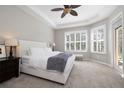 Bright main bedroom with tray ceiling, large windows, and plush carpet at 14809 Tudor Chase Dr, Tampa, FL 33626