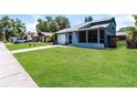 Single-story home with a well-manicured lawn, attached garage, and screened porch at 16012 Ballica Dr, Tampa, FL 33618
