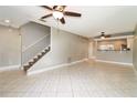Bright living room boasts tile flooring, a ceiling fan, and staircase at 16012 Ballica Dr, Tampa, FL 33618