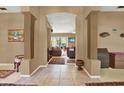 Hallway with pillars lead to a warm and inviting living room with neutral tones and a relaxing atmosphere at 17108 Longacres Ln, Odessa, FL 33556