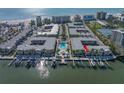 Aerial view showing waterfront condos with boat docks, beach, and a pool with stunning Gulf views at 19417 Gulf Blvd # B-210, Indian Shores, FL 33785
