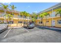 Exterior view of the condo showing parking and a maintained landscape with palm trees at 19417 Gulf Blvd # B-210, Indian Shores, FL 33785