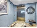 Elevator lobby featuring a stainless steel elevator and blue walls at 19816 Gulf Boulevard # 201, Indian Shores, FL 33785