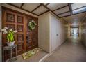 Condo entrance featuring an ornate wooden door, white wreath, and textured walls at 3021 Countryside Blvd # 24A, Clearwater, FL 33761