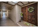 Condo entrance featuring an ornate wooden door, white wreath, and textured walls at 3021 Countryside Blvd # 24A, Clearwater, FL 33761