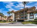 Three-story condo building has a brown roof and an attached covered carport at 3021 Countryside Blvd # 24A, Clearwater, FL 33761