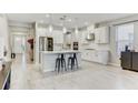 Spacious kitchen with a large island, modern pendant lighting, stainless steel appliances, and white cabinets at 33886 Landsman Loop, Wesley Chapel, FL 33543