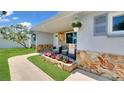 Inviting front porch featuring stone accents, seating area, and beautiful landscaping at 5248 Coral N Way, St Petersburg, FL 33714