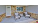 Inviting front porch features stone accent wall, seating, and front door at 5248 Coral N Way, St Petersburg, FL 33714