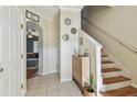 Welcoming foyer with tile flooring, staircase, and decor leading to a living area at 542 Black Lion Ne Dr, St Petersburg, FL 33716
