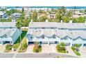 Charming blue townhouse with manicured lawn and a peek of the ocean in the background at 615 Garland Cir, Indian Rocks Beach, FL 33785
