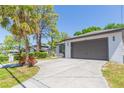 Single-story home featuring a spacious driveway, two-car garage, and palm tree at 6426 31St S St, St Petersburg, FL 33712