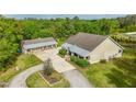 Sprawling property featuring a well-maintained home, detached garage, and lush green lawn at 6448 Country Club Rd, Wesley Chapel, FL 33544