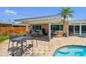 Covered outdoor patio with dining area, seating, and partial view of the pool at 6667 28Th S St, St Petersburg, FL 33712
