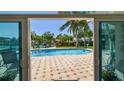 View of the sparkling pool and tropical backyard from inside the home through sliding glass doors at 6667 28Th S St, St Petersburg, FL 33712