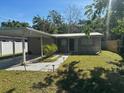 Single story home showing front door, windows, walkway lights, carport, and lawn at 7106 S Sparkman St, Tampa, FL 33616