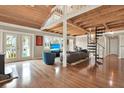 Open-concept living room with hardwood floors, wood-plank ceiling, and spiral staircase to the loft at 7500 141St St, Seminole, FL 33776