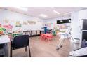 Spacious playroom with colorful decor, including tables and chairs, educational posters, and play equipment at 810 W Whatley Pl, Tampa, FL 33604