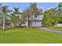 Charming two-story home featuring a lush front yard with mature trees and a cozy entrance at 8420 Orient Ne Way, St Petersburg, FL 33702