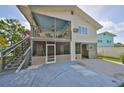 Two-story home featuring a screened-in porch, open upper deck and an outdoor staircase at 8420 Orient Ne Way, St Petersburg, FL 33702
