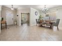 Inviting entryway leading to a spacious living room with large tiled floors, dining and a lovely chandelier at 12519 Safari Ln, Riverview, FL 33579