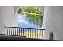 Scenic view of a fountain on a lake through an arched opening with a black metal safety railing at 1309 Pine Ridge E Cir # H3, Tarpon Springs, FL 34688