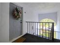 Gray front door with floral wreath, welcome mat, and unit number H3 located in a white hallway at 1309 Pine Ridge E Cir # H3, Tarpon Springs, FL 34688