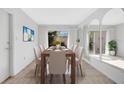 Bright dining room with a wooden table, seating for eight, and a sliding door to the outside at 13850 Sunset Dr, Largo, FL 33774