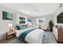 Comfortable bedroom with ceiling fan, two windows and decoratively coordinated bed linens and pillows at 13850 Sunset Dr, Largo, FL 33774