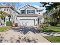 Two-story home features a wide driveway and an inviting front lawn with tidy landscaping at 14241 Natures Reserve Dr, Lithia, FL 33547