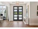 Elegant foyer featuring hardwood floors, a modern chandelier, and double doors with frosted glass at 16121 Carencia Ln, Odessa, FL 33556