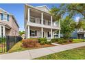 Beautiful two-story home with a covered porch and white columns, surrounded by lush greenery at 16906 Dorman Rd, Lithia, FL 33547