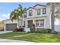 Beautifully landscaped two-story home with a charming front porch, gray double-door entry, and attached garage at 2904 W Averill Ave, Tampa, FL 33611