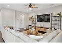 Bright living room features a ceiling fan, modern shelving and comfortable white couches at 2904 W Averill Ave, Tampa, FL 33611